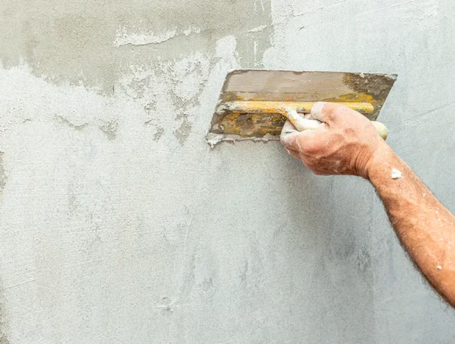 Application d'enduit à la chaux sur un mur à Strasbourg